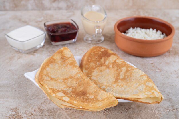 Pfannkuchen mit Quark und Erdbeermarmelade rollen