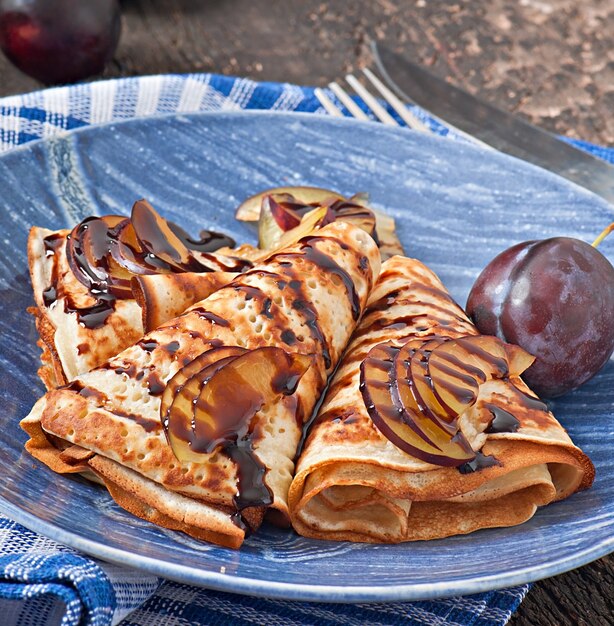 Pfannkuchen mit Schokoladensirup und Pflaumen