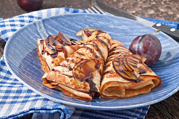 Pfannkuchen mit Schokoladensirup und Pflaumen