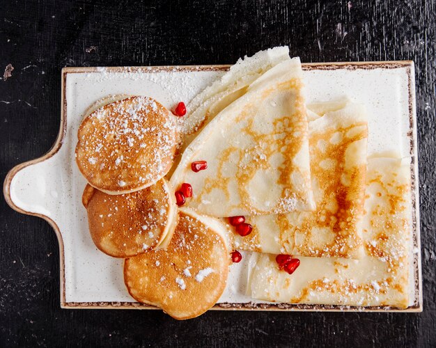 Pfannkuchen und Crepes mit Puderzucker und Granatapfel in der Draufsicht