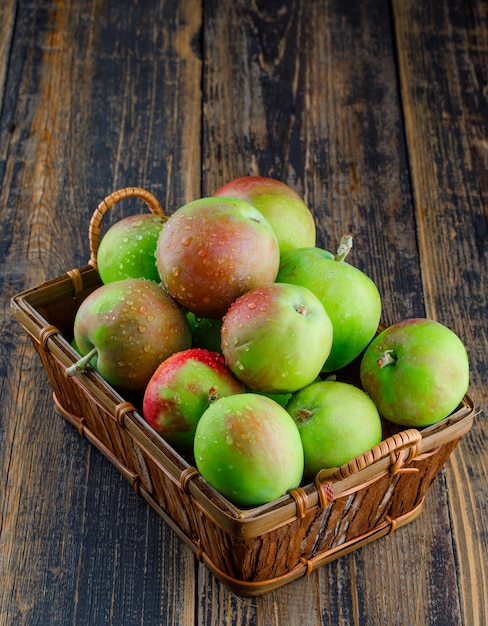 Äpfel in einem Korb auf hölzernem Hintergrund, hohe Winkelansicht.