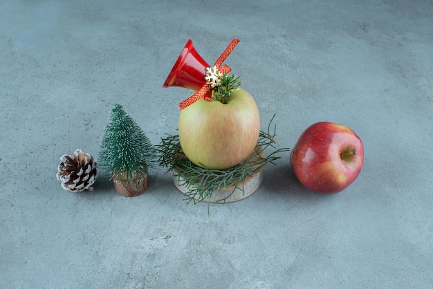 Äpfel und festliche Weihnachtsdekorationen auf Marmor.