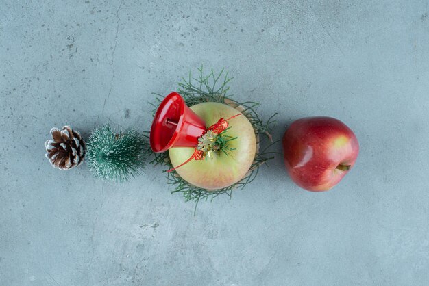 Äpfel und festliche Weihnachtsdekorationen auf Marmor.