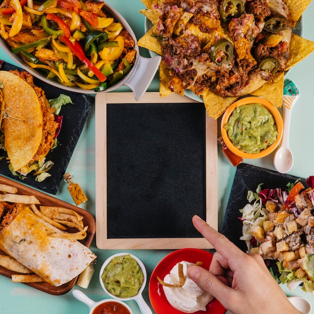 Kostenloses Foto pflanzen sie die hand, die auf tafel nahe tellern zeigt