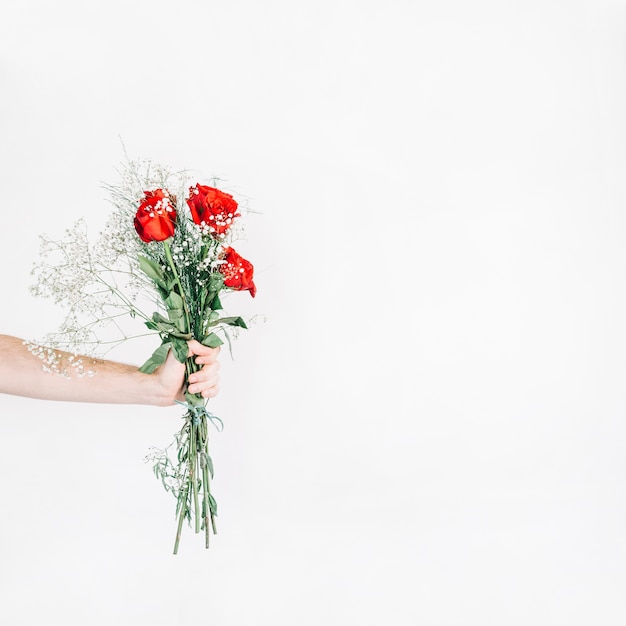 Pflanzen Sie die Hand, die Blumenstrauß mit Rosen zeigt