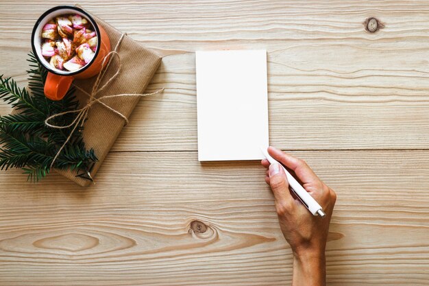 Pflanzenhandschrift im Notizbuch nahe Geschenk und Getränk