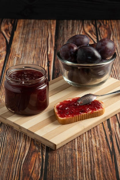 Pflaumenkonfitüre im Glas und auf dem Toast.