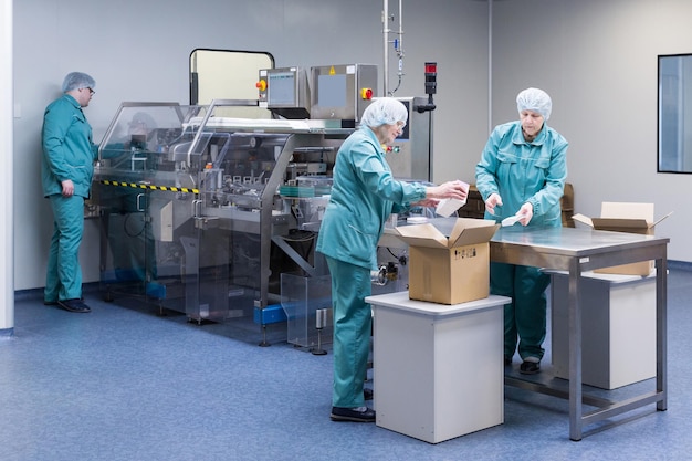 Kostenloses Foto pharmazeutische techniker arbeiten unter sterilen arbeitsbedingungen in einer pharmazeutischen fabrik wissenschaftler in schutzkleidung