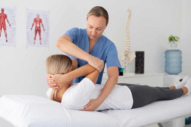 Physiotherapeut hilft einer jungen Patientin