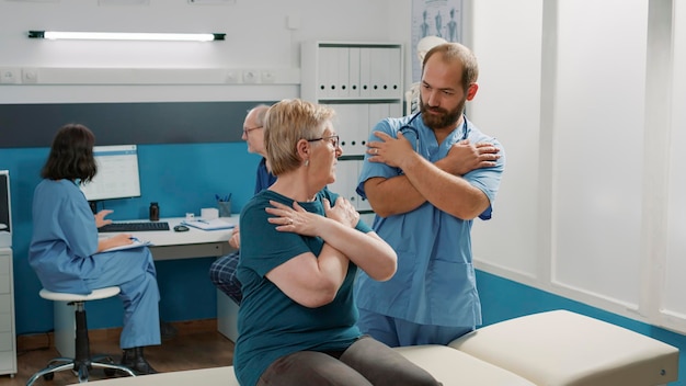 Physiotherapeut knackt Rückenknochen, um älteren Patienten zu helfen, die Mobilität zu erhöhen und Verletzungen zu heilen. Osteopath und alte Frau dehnen Muskeln bei Physiotherapie, Rehabilitationsprogramm.