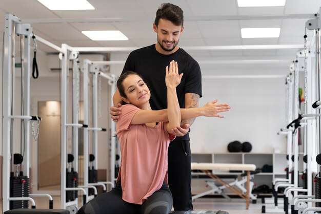 Physiotherapeutin mit mittlerem Schuss, die Frau hilft