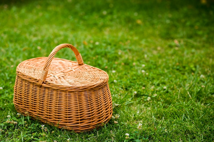 Kostenlose Foto picknickkorb auf einem rasenfeld