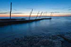 Kostenloses Foto pier unter dem schönen sonnenuntergangshimmel in der adria in savudrija in istrien, kroatien