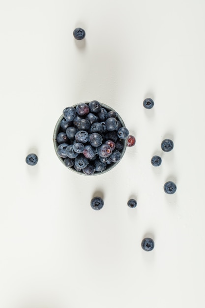 Pikante Blaubeeren in einem Mini-Eimer auf weißer Oberfläche