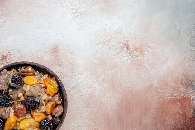 Pilaf-Pilaw von oben mit getrockneten Früchten auf dem cremebraun-grauen Tisch