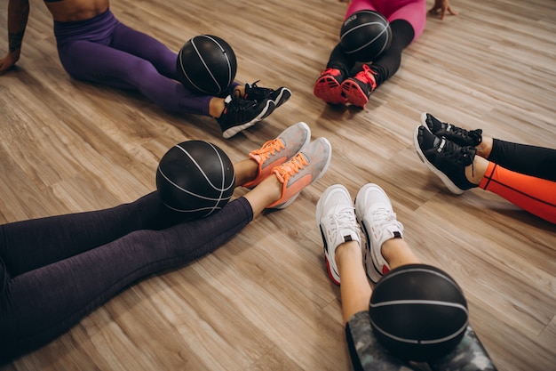 Pilates-Gruppe, die in einer Turnhalle ausarbeitet