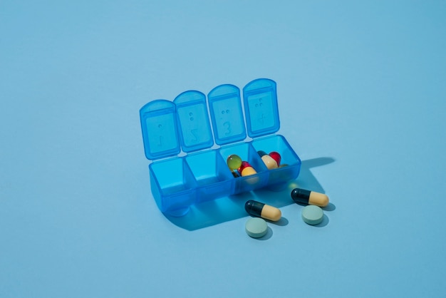Kostenloses Foto pillenbehälter auf blauem hintergrund