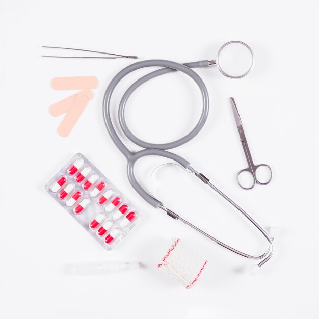 Pillenblisterpackung mit Stethoskop und medizinischen Geräten auf weißem Hintergrund