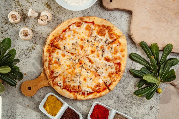 Pilzpizza mit Pilzen und Gewürzen auf dem Tisch