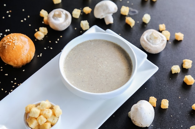 Pilzsuppe in der Schüssel Cracker Brötchen Sesam Seitenansicht