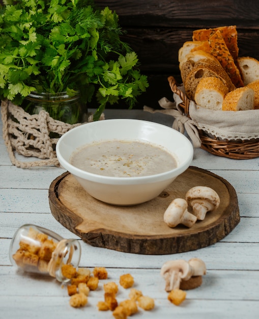 Pilzsuppe mit Brotfüllung auf Holzbrett serviert