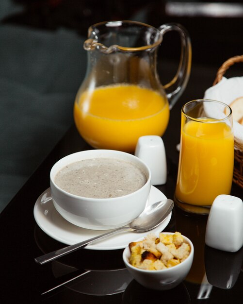 Kostenloses Foto pilzsuppe mit orangensaft und crackern.