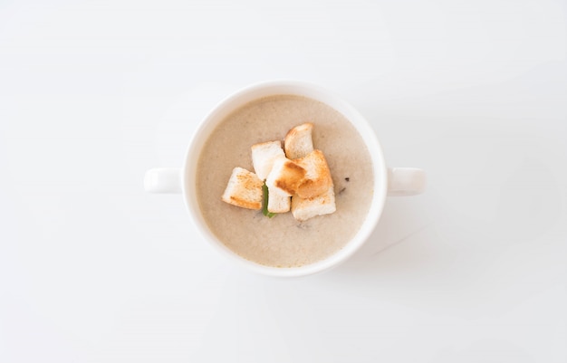 Pilzsuppe und Brot in weissem Keramikbecher