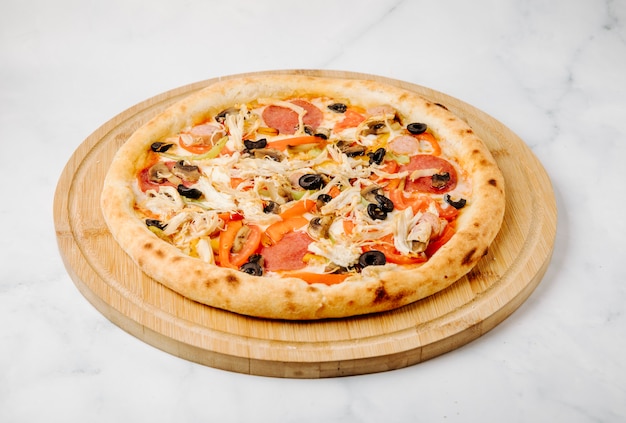 Pizza aus verschiedenen Zutaten mit Oliven, Tomaten und Peperoni.