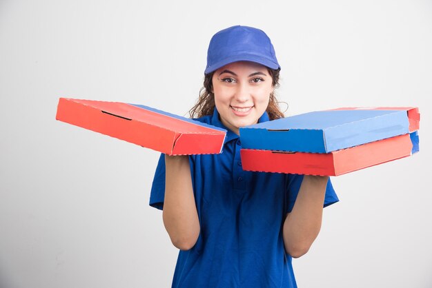 Pizza delivery girl hält drei boxen auf weißem hintergrund. hochwertiges foto