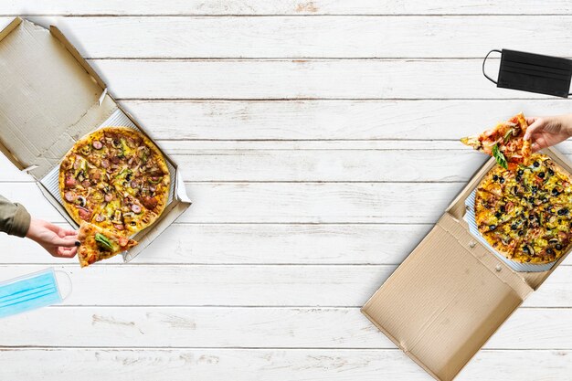 Pizza essen mit sozialer Distanzierung auf die neue normale Art und Weise