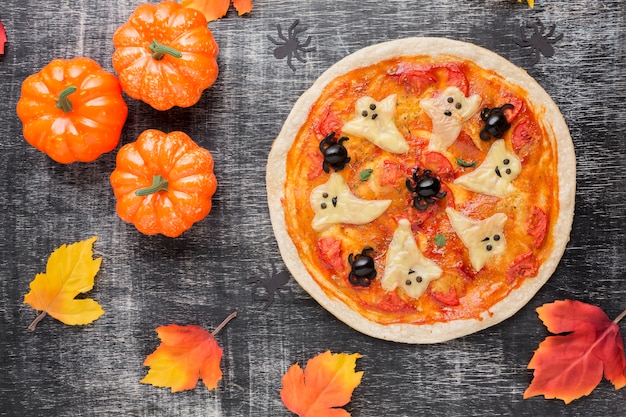 Pizza mit gruseligen Geistern an der Spitze und Kürbisse