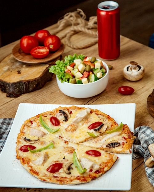 Pizza mit Hühnerpilzen und Gemüsesalat