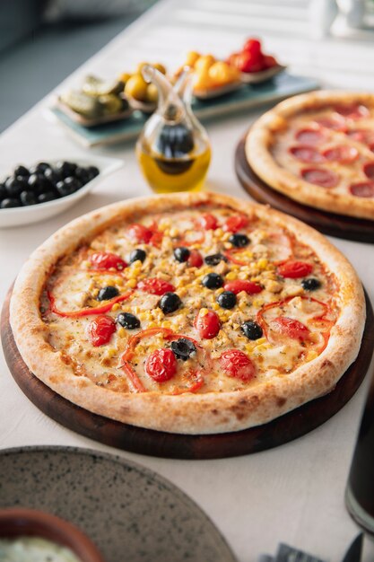 Pizza mit Oliven Paprika Tomaten und Mais