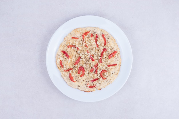 Pizza mit Paprika auf Holzteller auf Weiß