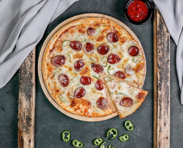 Pizza mit Peperoni und roter Chili-Sauce
