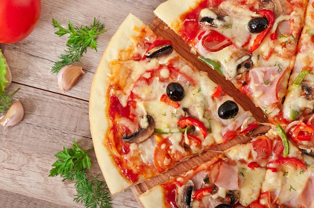 Pizza mit Schinken, Champignons und Oliven