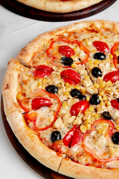 Pizza mit Tomaten, Oliven, Paprika und Mais