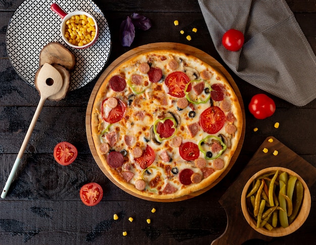 Pizza mit Tomatenscheiben und Peperoni.