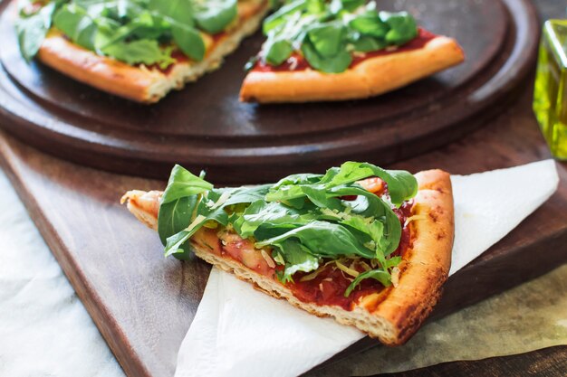 Pizzastückchen auf Seidenpapier über dem Schneidebrett