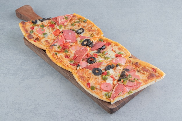 Pizzastücke auf einem kleinen Tablett auf Marmor gebündelt