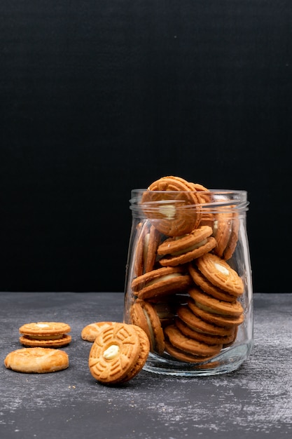 Plätzchen in einem Glasgefäß auf dunkler Oberfläche