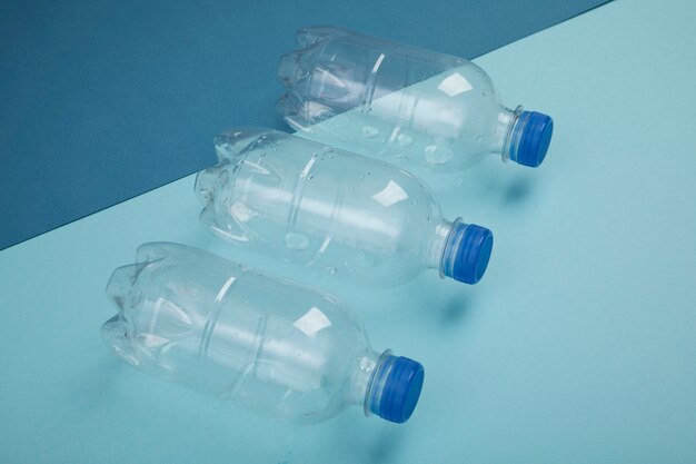 Plastikflaschen des hohen Winkels auf blauem Hintergrund