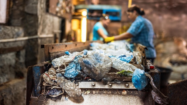 Kostenloses Foto plastikmüll auf einem förderband in der abfallrecyclingfabrik arbeiter im hintergrund