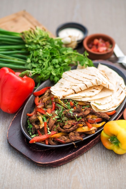 Platte mit gebratenen, dünnen Lammscheiben, gekocht mit buntem Paprika