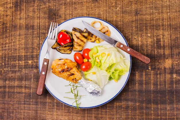 Platte mit gegrilltem Fleisch und rohem Gemüse