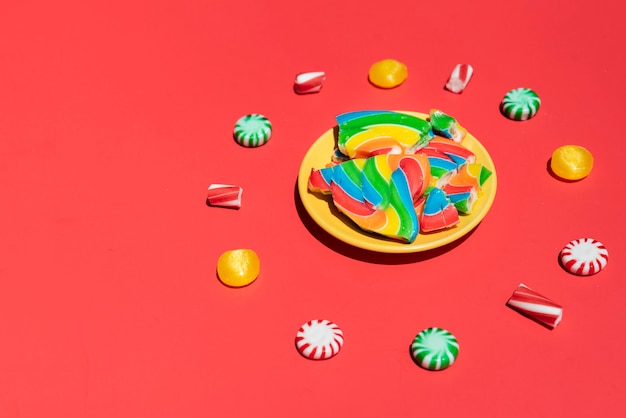 Platte mit geräuchertem Lutscher umgeben von Süßigkeiten