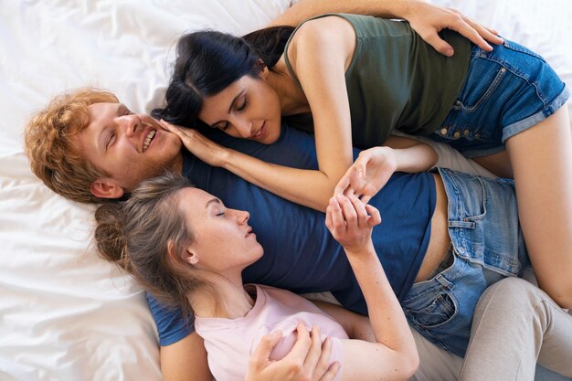 Polyamoreses Paar zu Hause im Bett