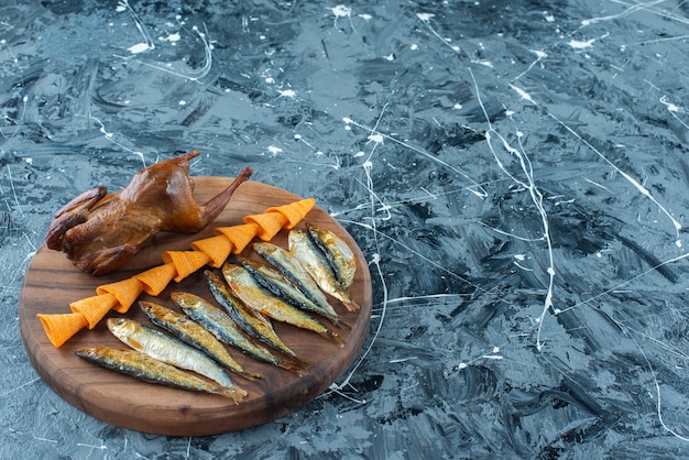 Pommes, Grill Huhn und Fisch auf einem Brett, auf dem Marmorhintergrund.