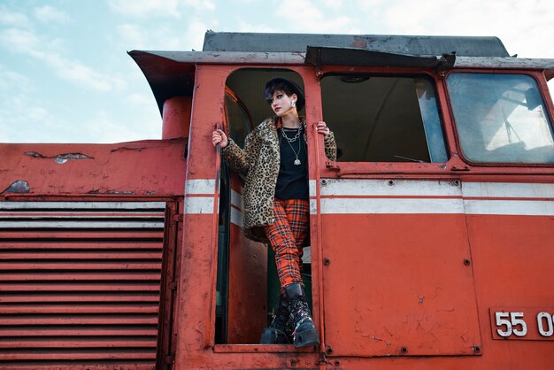 Pop-Punk-ästhetisches Porträt einer Frau, die in Lokomotive posiert