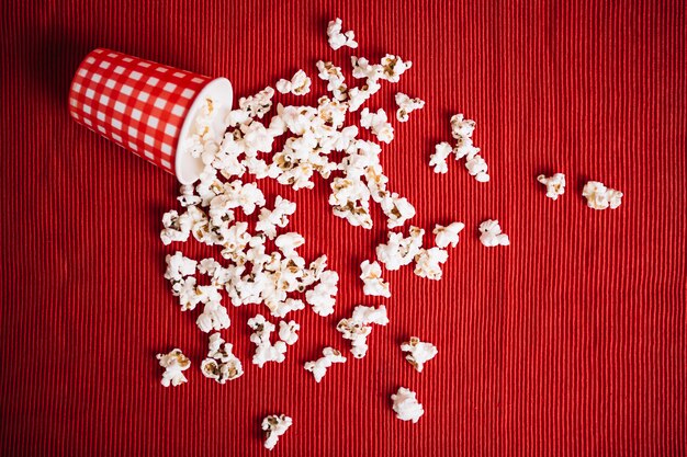 Kostenloses Foto popcorn aus karierten tasse verschüttet